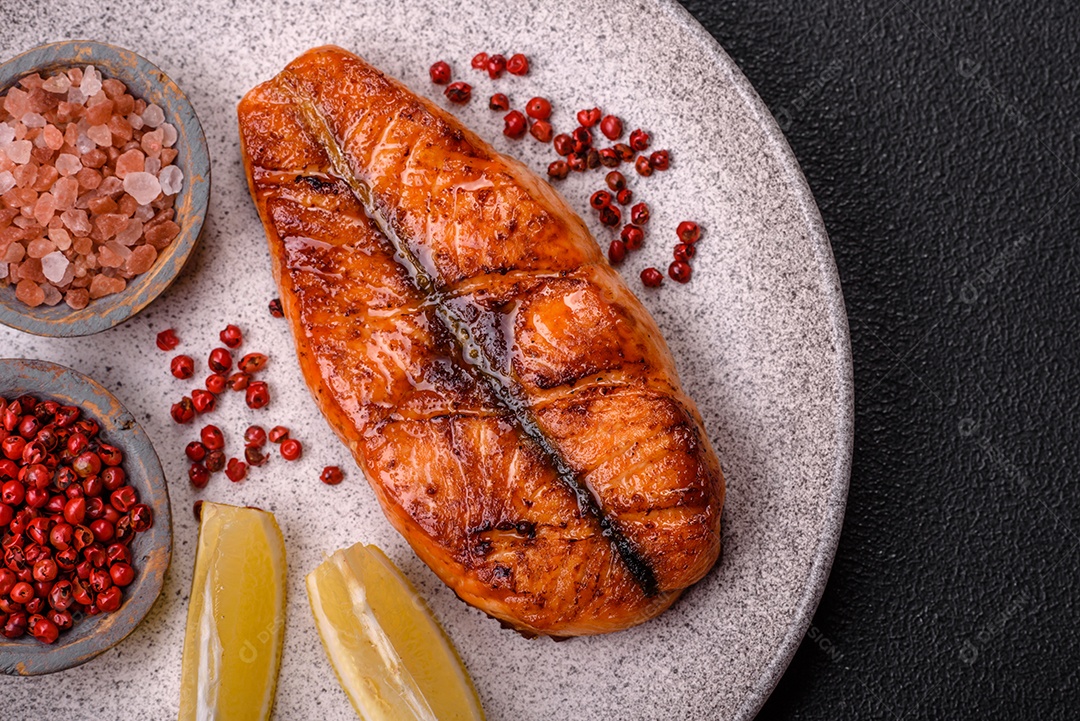 Bife de salmão delicioso cozido fresco com especiarias e ervas assadas em uma grelha. Comida saudável de frutos do mar