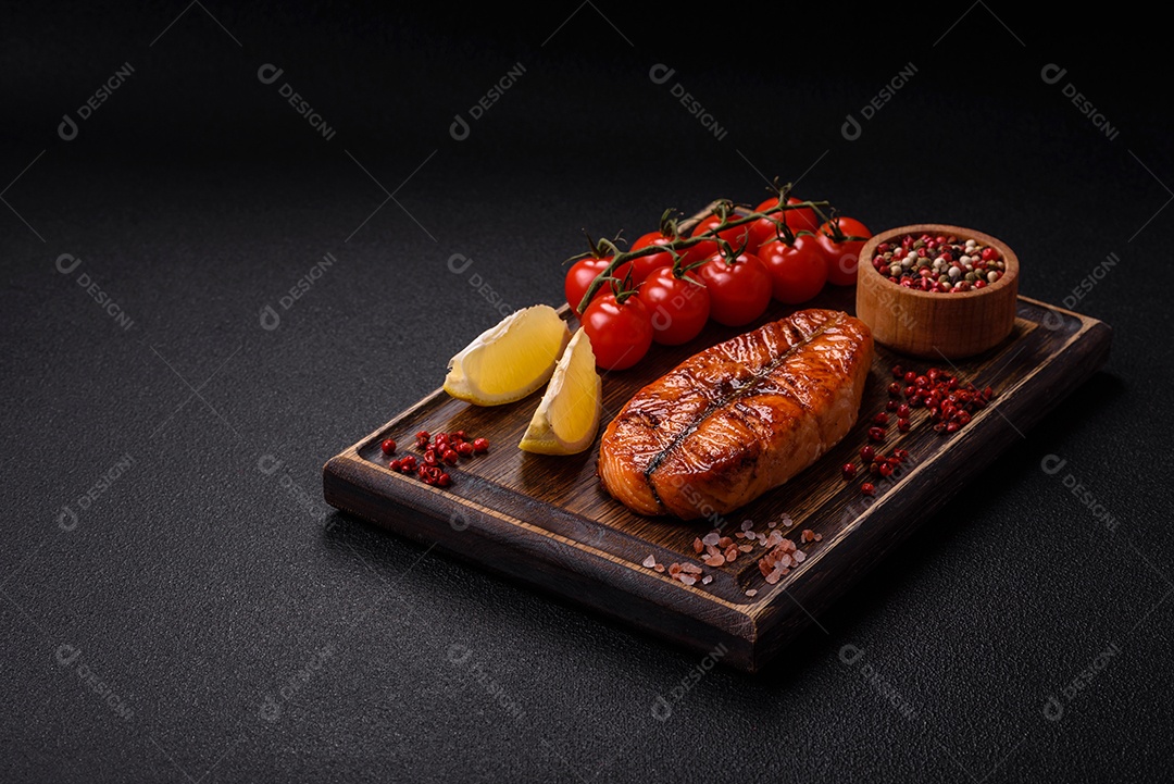 Bife de salmão delicioso cozido fresco com especiarias e ervas assadas em uma grelha. Comida saudável de frutos do mar