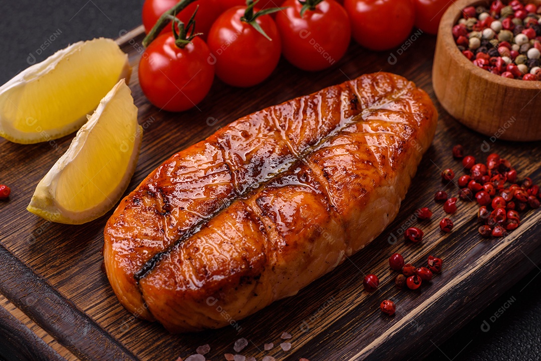 Bife de salmão delicioso cozido fresco com especiarias e ervas assadas em uma grelha. Comida saudável de frutos do mar