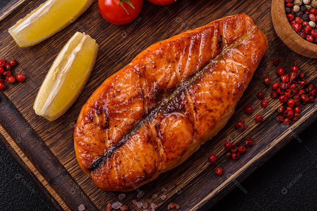 Bife de salmão delicioso cozido fresco com especiarias e ervas assadas em uma grelha. Comida saudável de frutos do mar