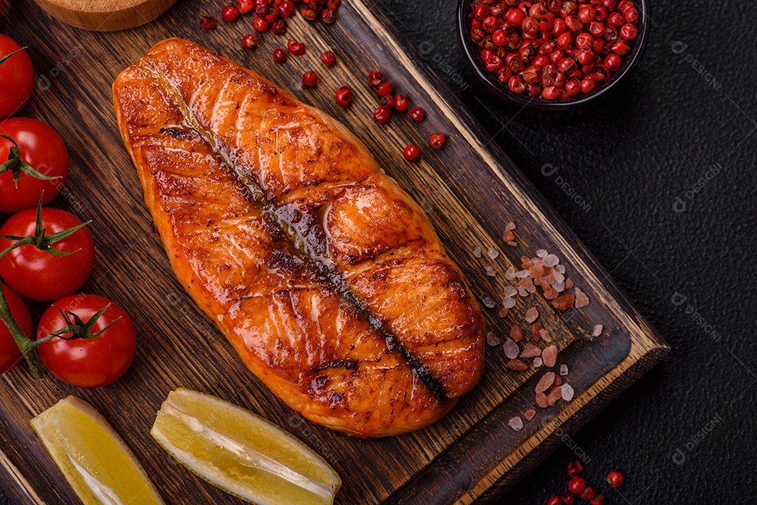 Bife de salmão delicioso cozido fresco com especiarias e ervas assadas em uma grelha. Comida saudável de frutos do mar