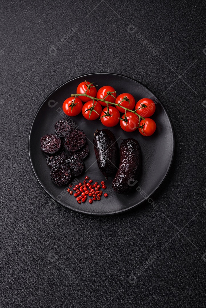 Delicioso chouriço preto ou morcela com especiarias e ervas grelhadas sobre fundo de concreto preto