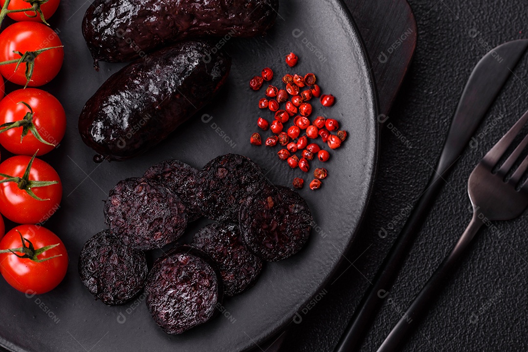Delicioso chouriço preto ou morcela com especiarias e ervas grelhadas sobre fundo de concreto preto
