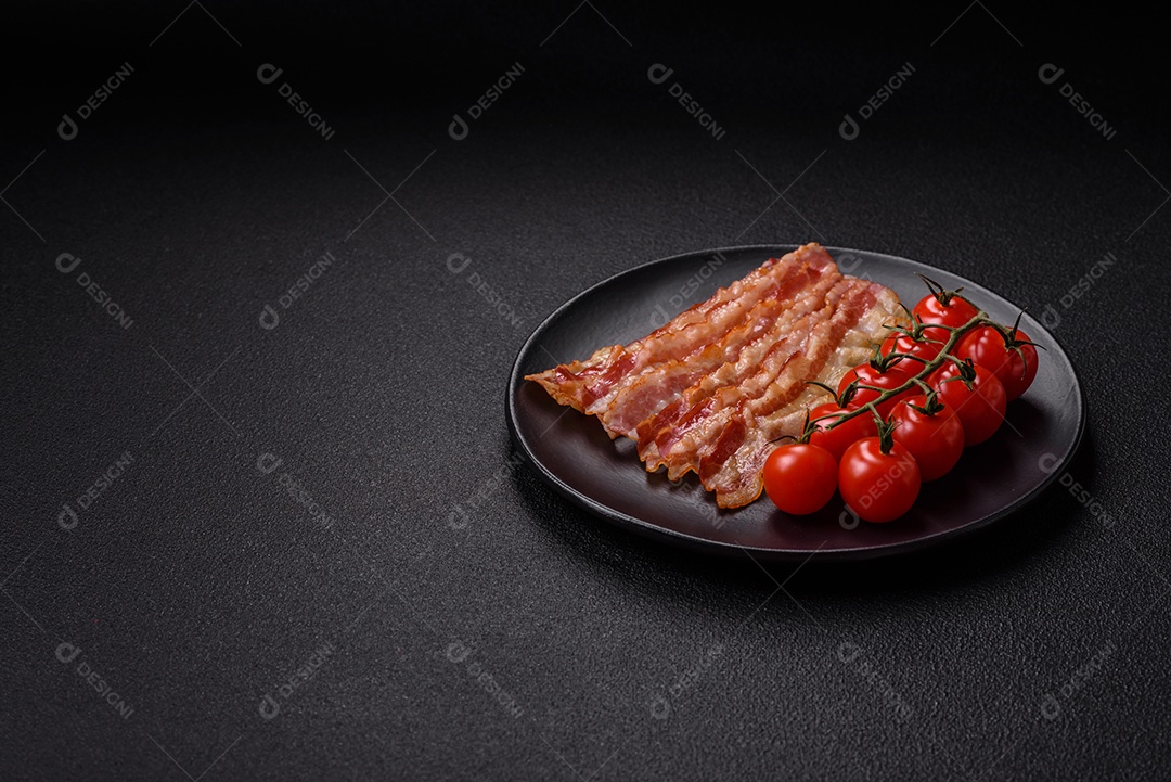 Delicioso bacon em forma de fatias com sal, especiarias e ervas sobre um fundo escuro de concreto