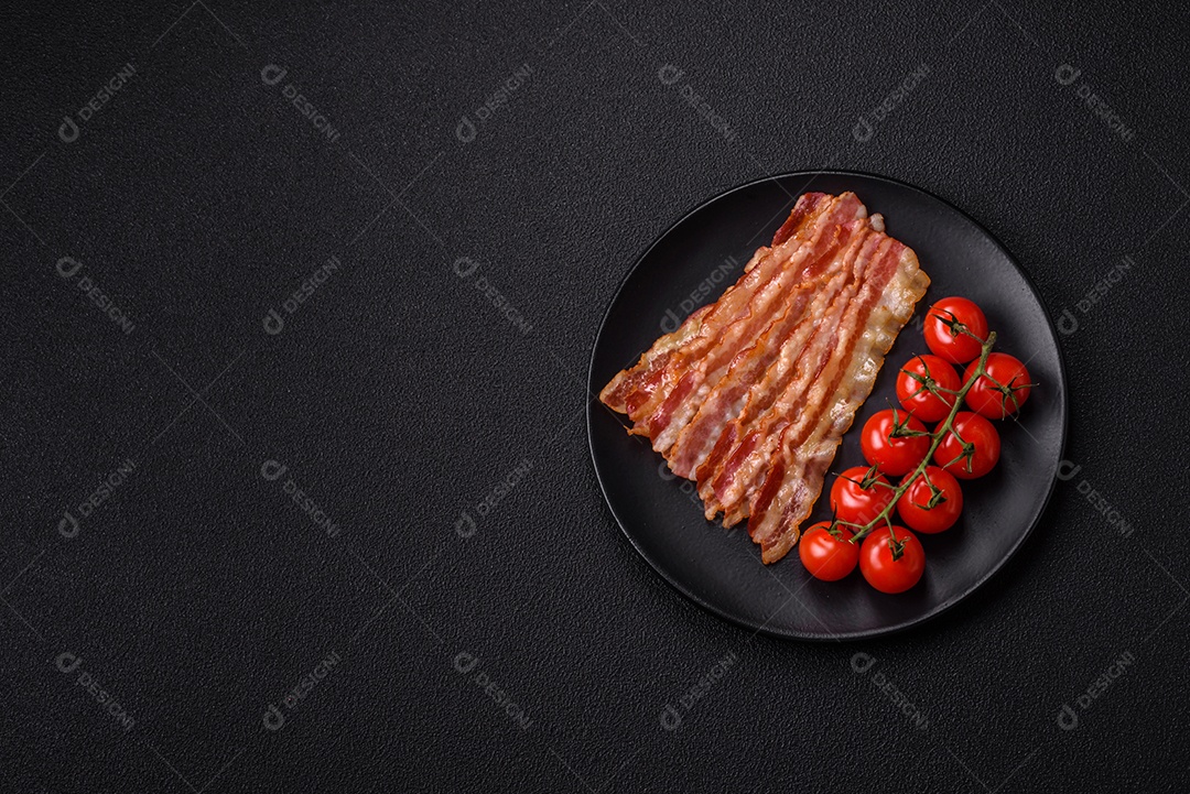 Delicioso bacon em forma de fatias com sal, especiarias e ervas sobre um fundo escuro de concreto