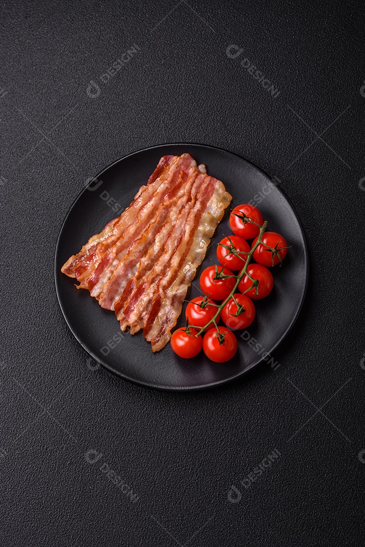 Delicioso bacon em forma de fatias com sal, especiarias e ervas sobre um fundo escuro de concreto
