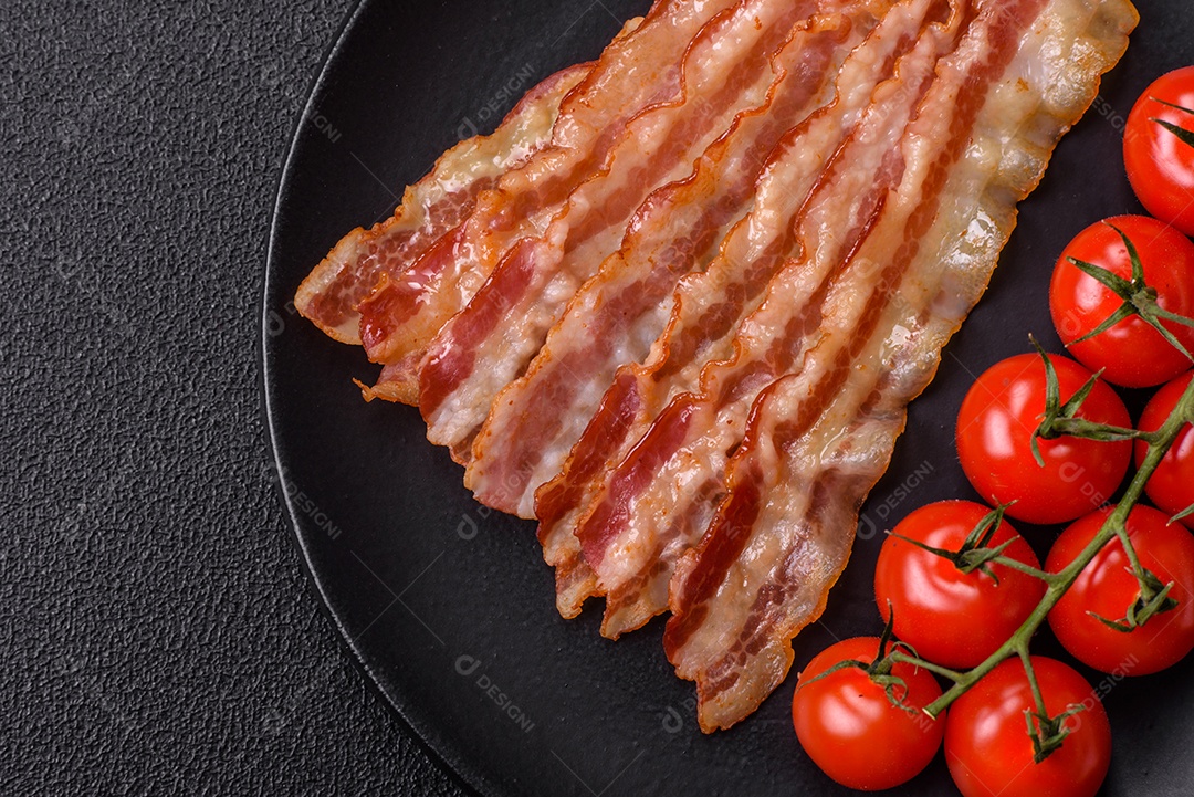 Delicioso bacon em forma de fatias com sal, especiarias e ervas sobre um fundo escuro de concreto