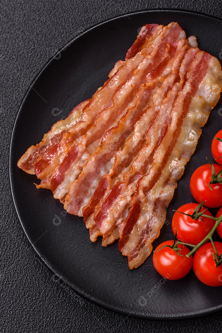 Delicioso bacon em forma de fatias com sal, especiarias e ervas sobre um fundo escuro de concreto