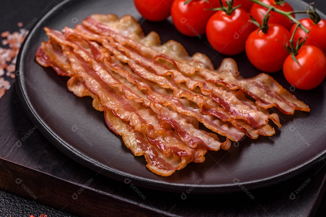 Delicioso bacon em forma de fatias com sal, especiarias e ervas sobre um fundo escuro de concreto