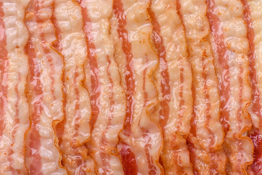 Delicioso bacon em forma de fatias com sal, especiarias e ervas sobre um fundo escuro de concreto