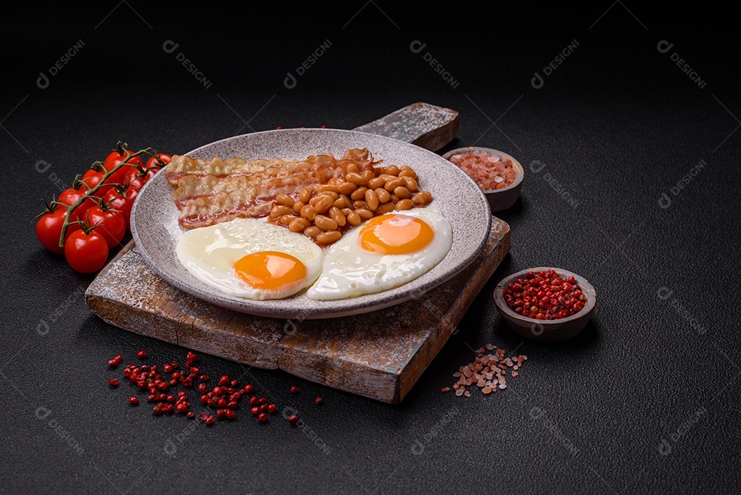 Café da manhã inglês com ovos fritos, bacon, feijão, tomate, especiarias e ervas. Um início de dia saudável e nutritivo