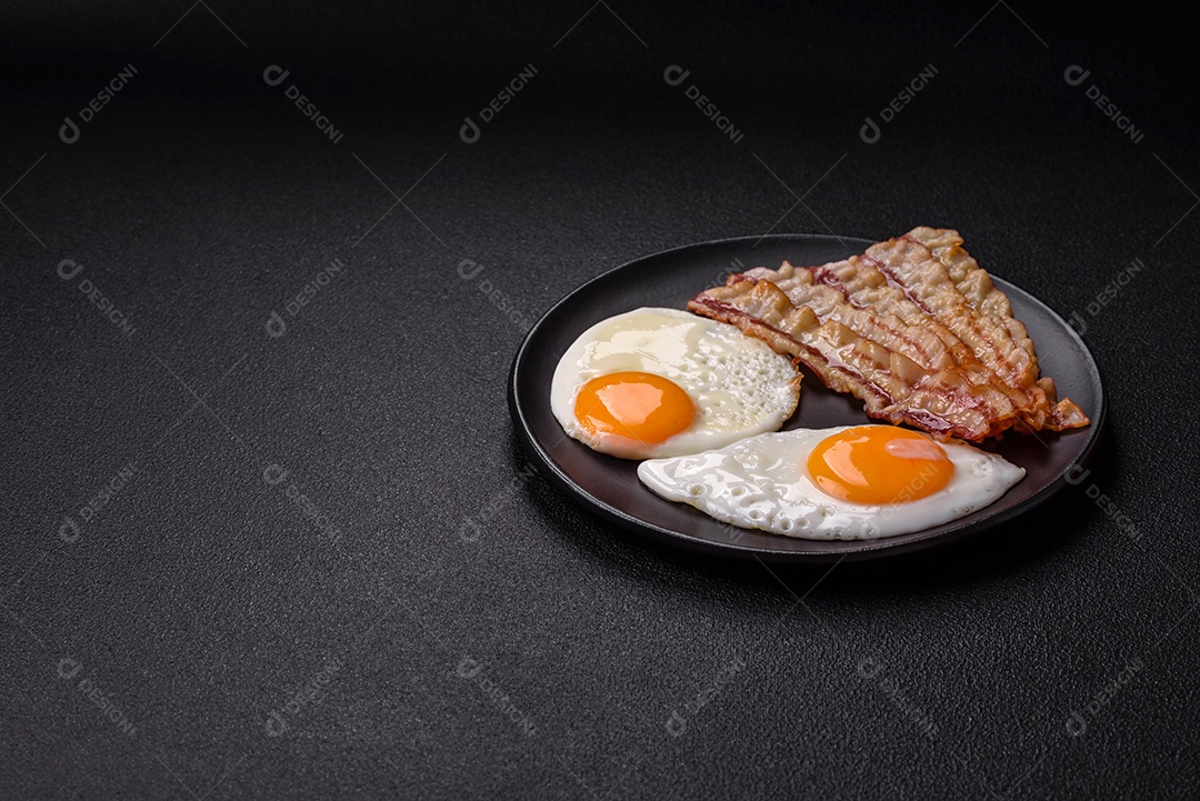 Delicioso bacon em forma de fatias com sal, especiarias e ervas sobre um fundo escuro de concreto