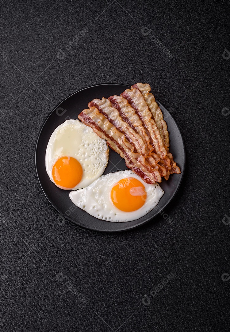 Café da manhã inglês com ovos fritos, bacon, feijão, tomate, especiarias e ervas. Um início de dia saudável e nutritivo