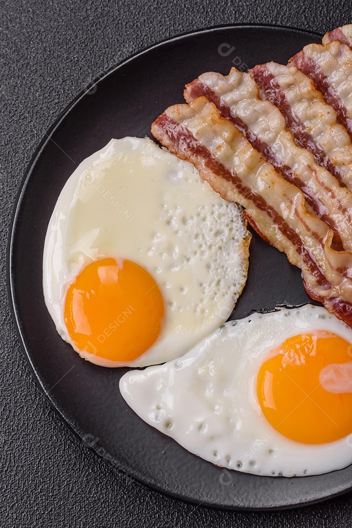 Café da manhã inglês com ovos fritos, bacon, feijão, tomate, especiarias e ervas. Um início de dia saudável e nutritivo