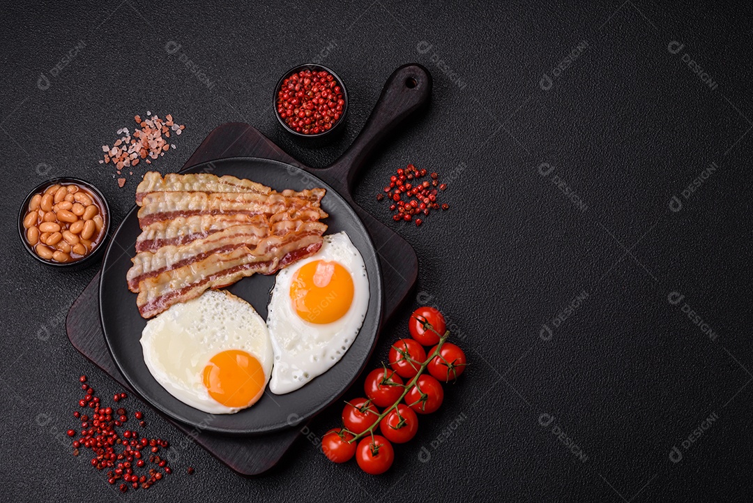 Café da manhã inglês com ovos fritos, bacon, feijão, tomate, especiarias e ervas. Um início de dia saudável e nutritivo