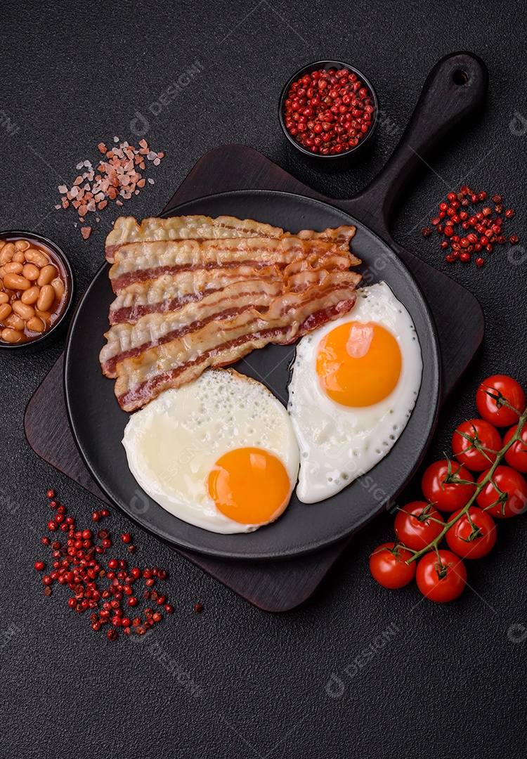 Café da manhã inglês com ovos fritos, bacon, feijão, tomate, especiarias e ervas. Um início de dia saudável e nutritivo