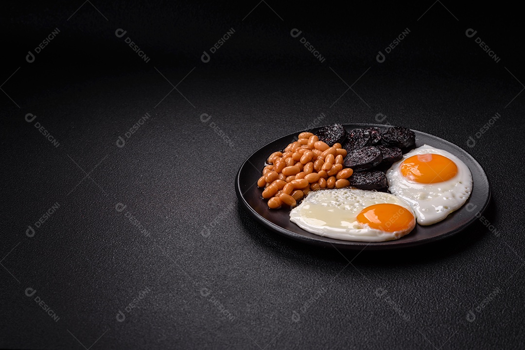 Café da manhã inglês com ovos fritos, bacon, feijão, tomate, especiarias e ervas. Um início de dia saudável e nutritivo