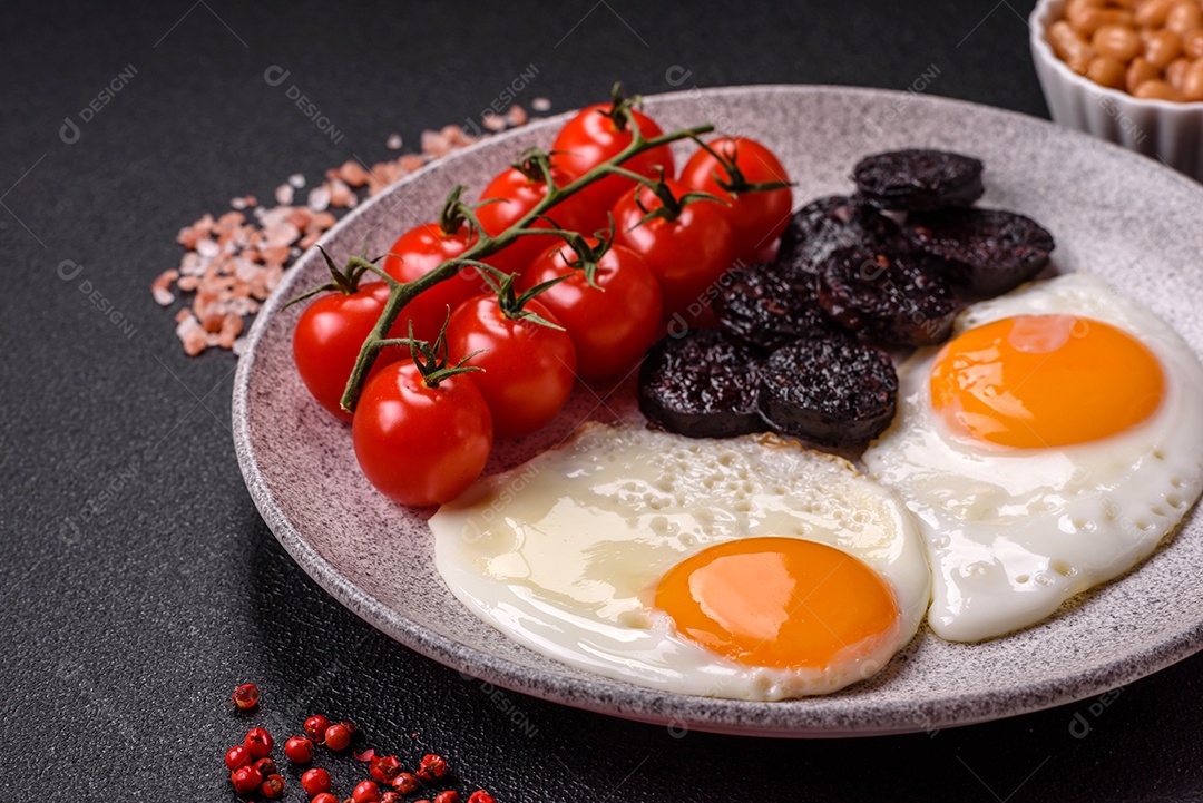 Café da manhã inglês com ovos fritos, bacon, feijão, tomate, especiarias e ervas. Um início de dia saudável e nutritivo