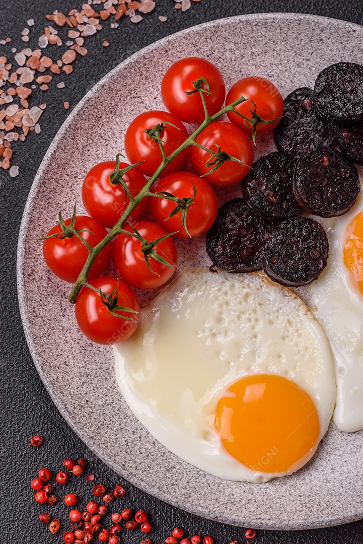 Café da manhã inglês com ovos fritos, bacon, feijão, tomate, especiarias e ervas. Um início de dia saudável e nutritivo