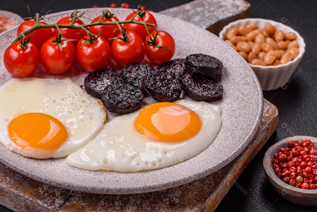 Café da manhã inglês com ovos fritos, bacon, feijão, tomate, especiarias e ervas. Um início de dia saudável e nutritivo