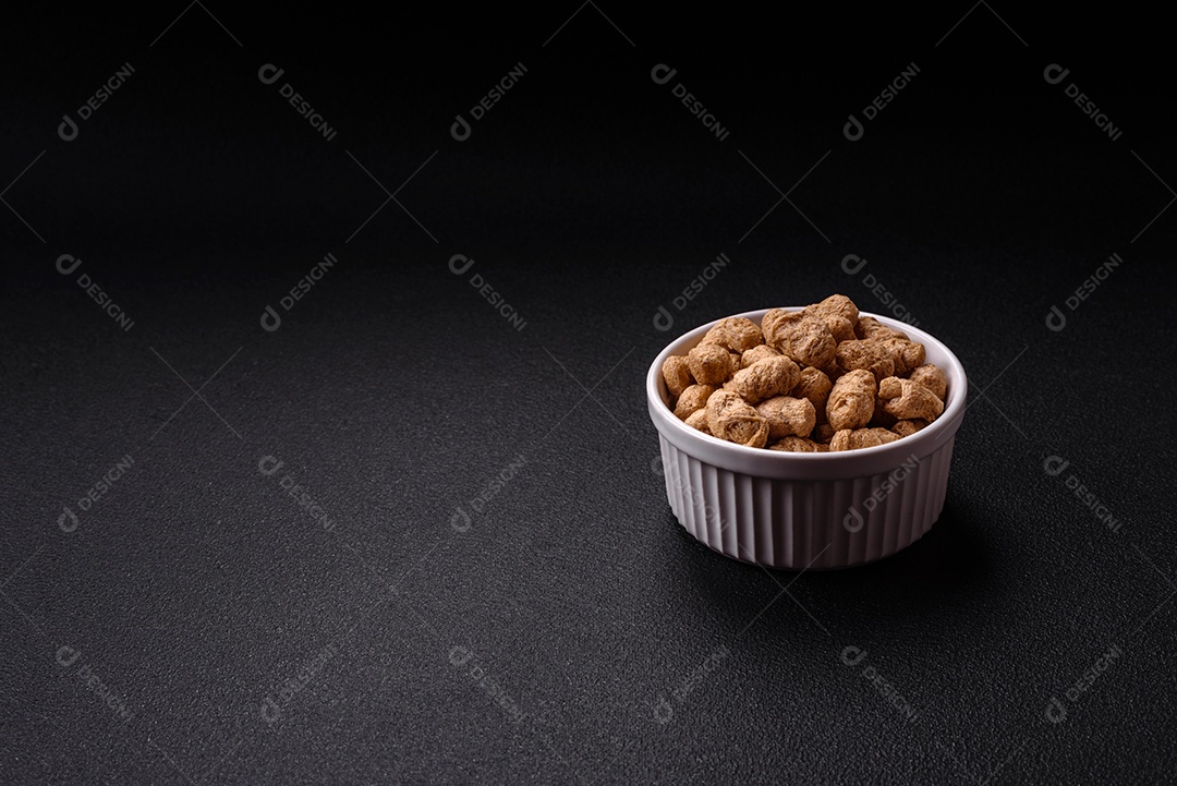 Pellets de carne de soja seca, alimentos dietéticos para cozinha vegana e vegetariana em fundo escuro de concreto