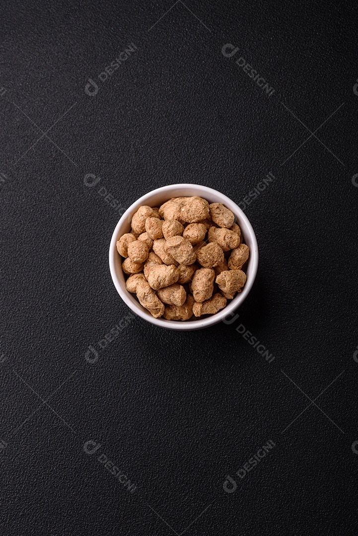 Pellets de carne de soja seca, alimentos dietéticos para cozinha vegana e vegetariana em fundo escuro de concreto