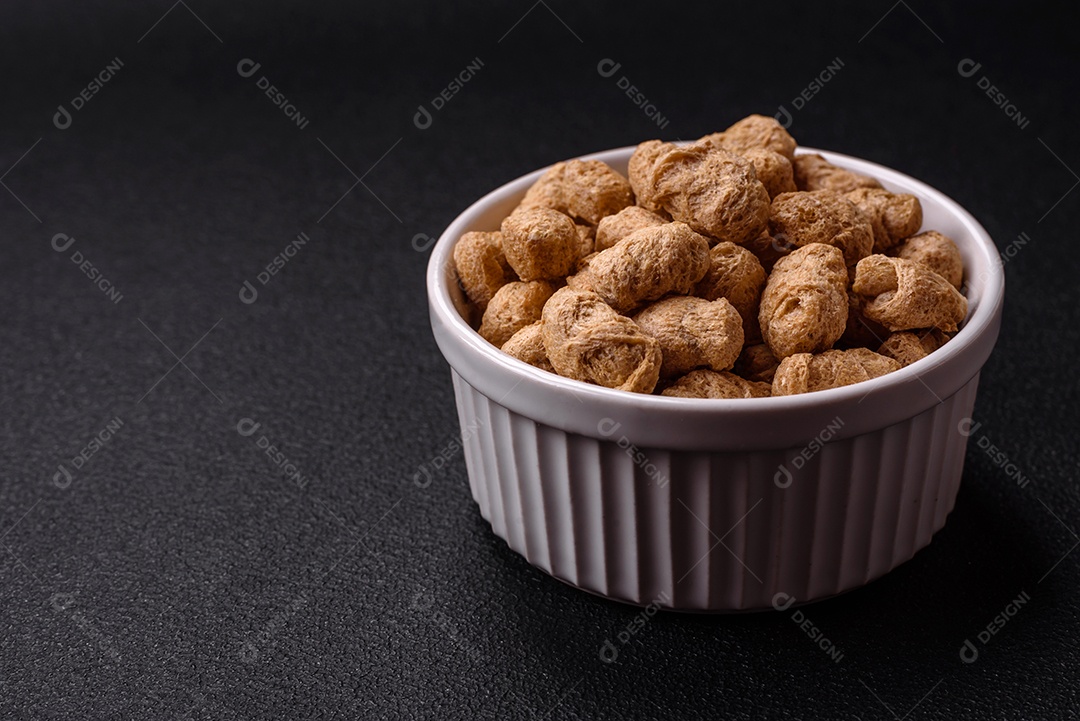 Pellets de carne de soja seca, alimentos dietéticos para cozinha vegana e vegetariana em fundo escuro de concreto