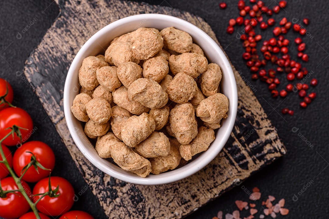 Pellets de carne de soja seca, alimentos dietéticos para cozinha vegana e vegetariana em fundo escuro de concreto