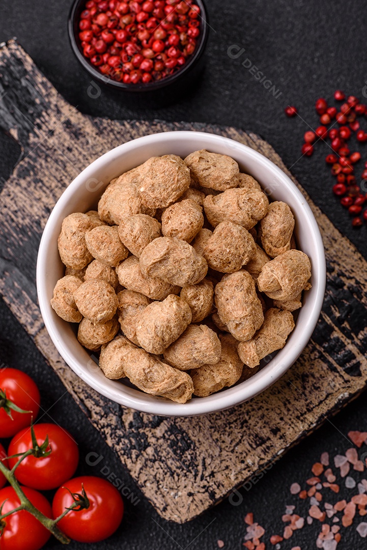 Pellets de carne de soja seca, alimentos dietéticos para cozinha vegana e vegetariana em fundo escuro de concreto