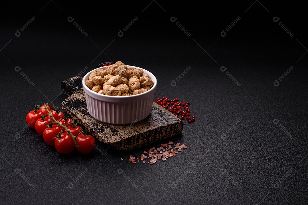 Pellets de carne de soja seca, alimentos dietéticos para cozinha vegana e vegetariana em fundo escuro de concreto