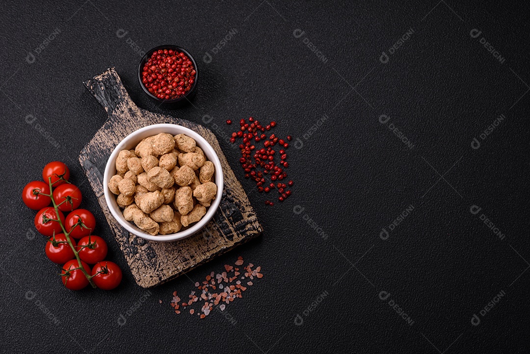 Pellets de carne de soja seca, alimentos dietéticos para cozinha vegana e vegetariana em fundo escuro de concreto