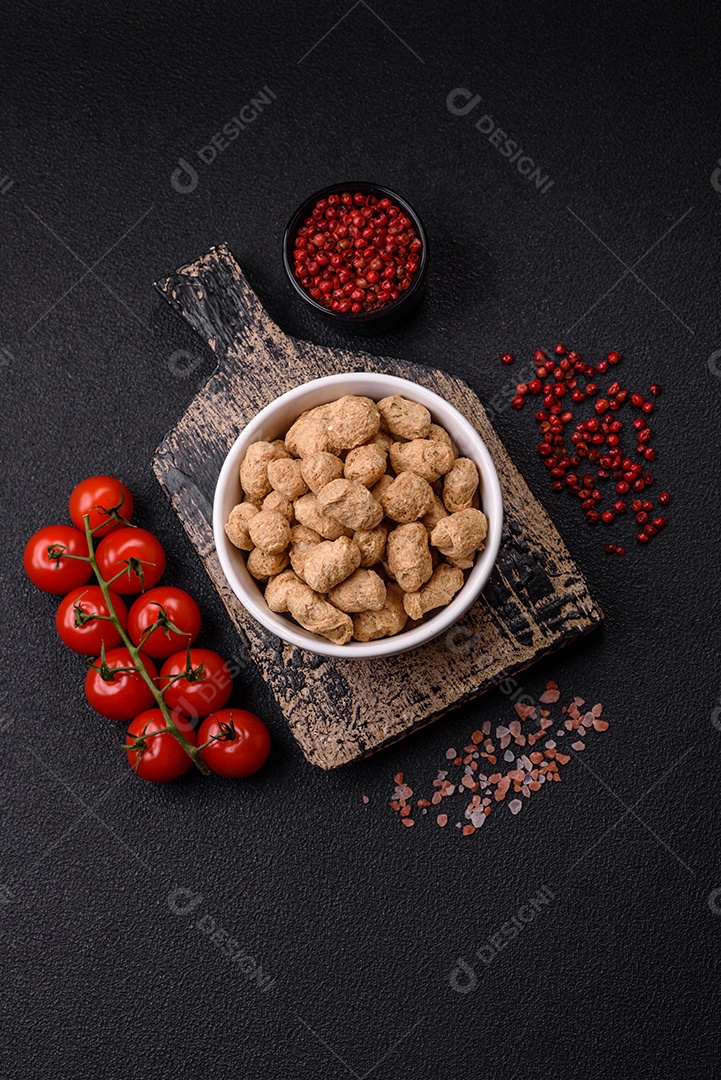 Pellets de carne de soja seca, alimentos dietéticos para cozinha vegana e vegetariana em fundo escuro de concreto