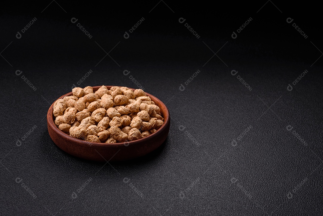 Pellets de carne de soja seca, alimentos dietéticos para cozinha vegana e vegetariana em fundo escuro de concreto