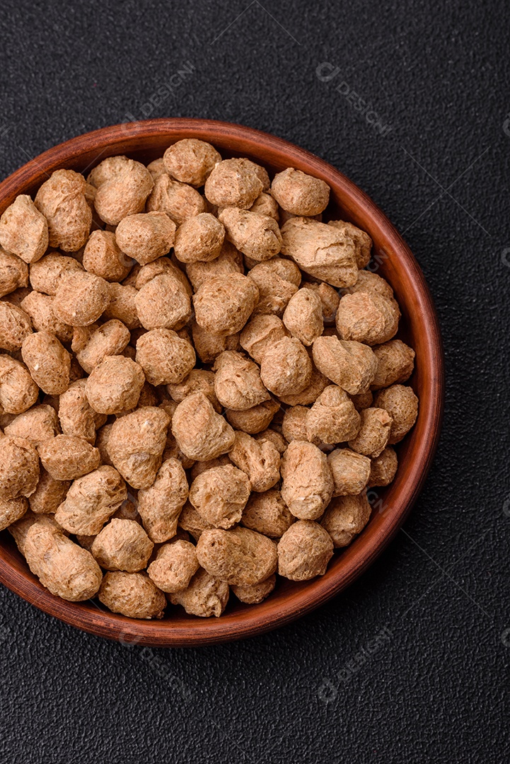 Pellets de carne de soja seca, alimentos dietéticos para cozinha vegana e vegetariana em fundo escuro de concreto