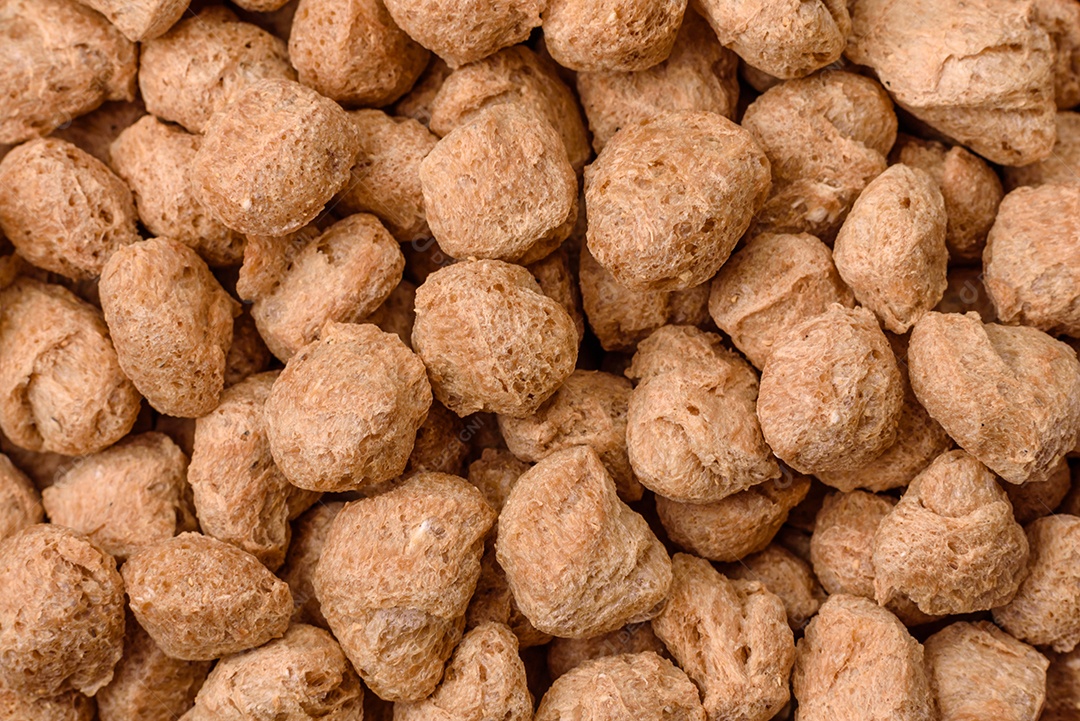 Pellets de carne de soja seca, alimentos dietéticos para cozinha vegana e vegetariana em fundo escuro de concreto