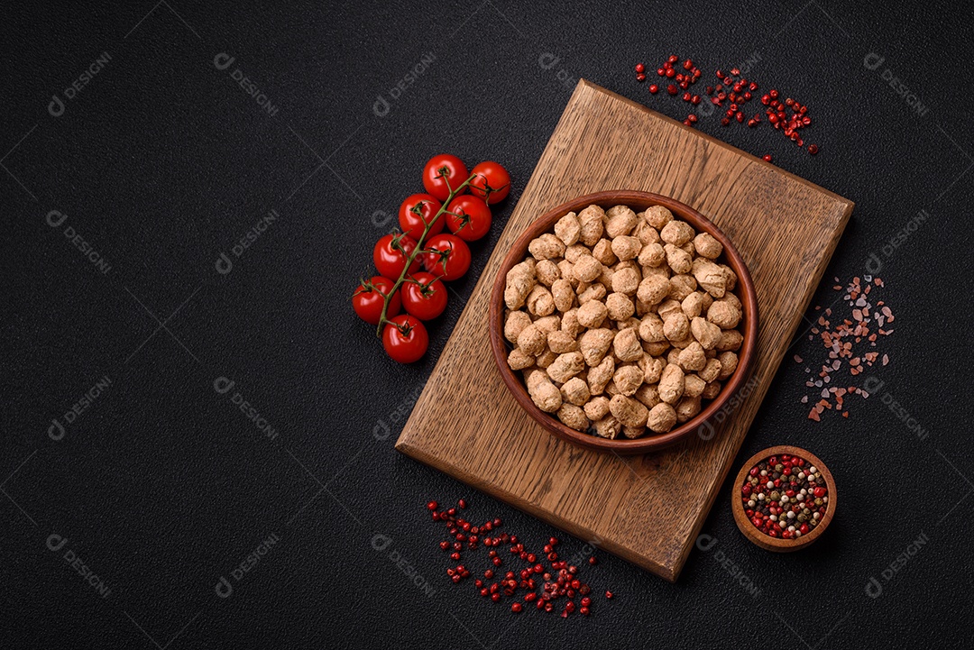 Pellets de carne de soja seca, alimentos dietéticos para cozinha vegana e vegetariana em fundo escuro de concreto