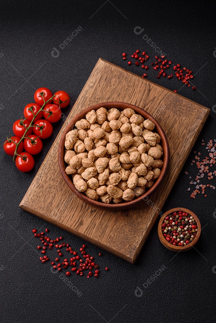 Pellets de carne de soja seca, alimentos dietéticos para cozinha vegana e vegetariana em fundo escuro de concreto