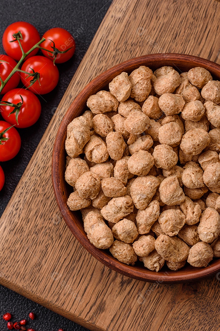 Pellets de carne de soja seca, alimentos dietéticos para cozinha vegana e vegetariana em fundo escuro de concreto