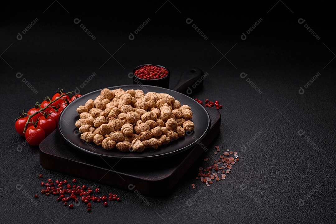 Pellets de carne de soja seca, alimentos dietéticos para cozinha vegana e vegetariana em fundo escuro de concreto