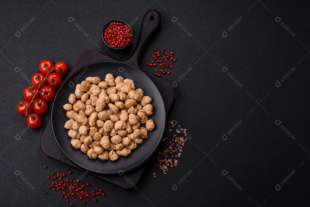 Pellets de carne de soja seca, alimentos dietéticos para cozinha vegana e vegetariana em fundo escuro de concreto