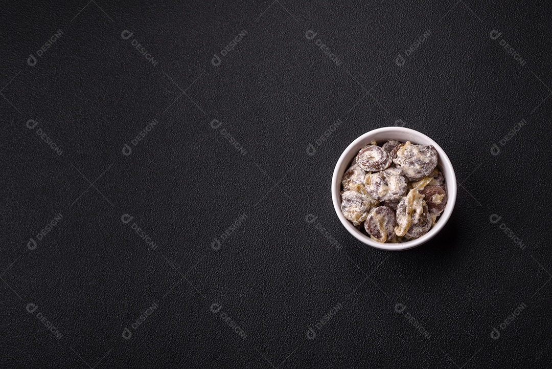 Corações de frango cozido cortados em fatias com cebola e molho cremoso com sal e especiarias sobre um fundo escuro de concreto