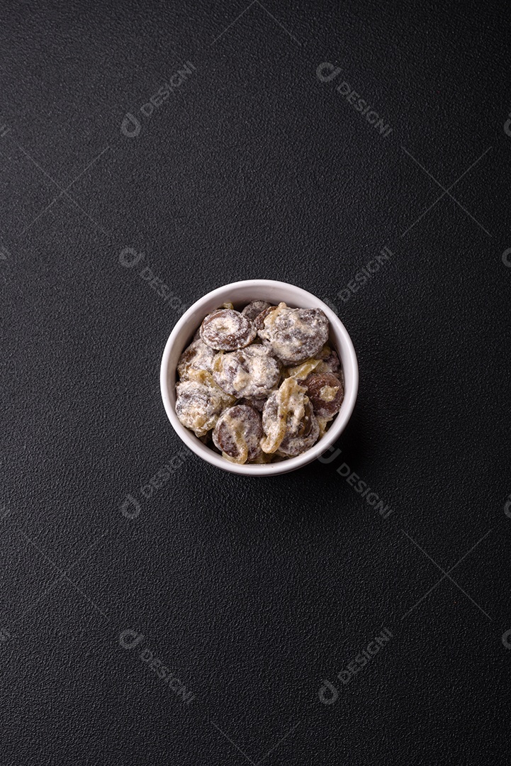 Corações de frango cozido cortados em fatias com cebola e molho cremoso com sal e especiarias sobre um fundo escuro de concreto