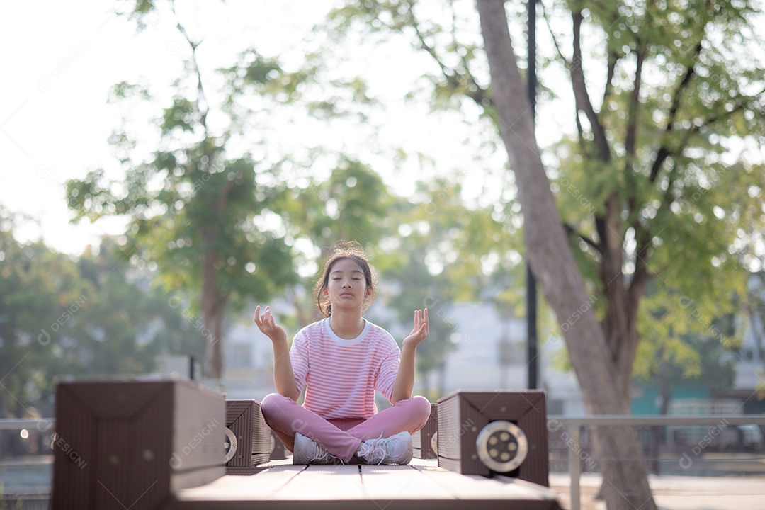 Garotinha meditando sentada em uma praça