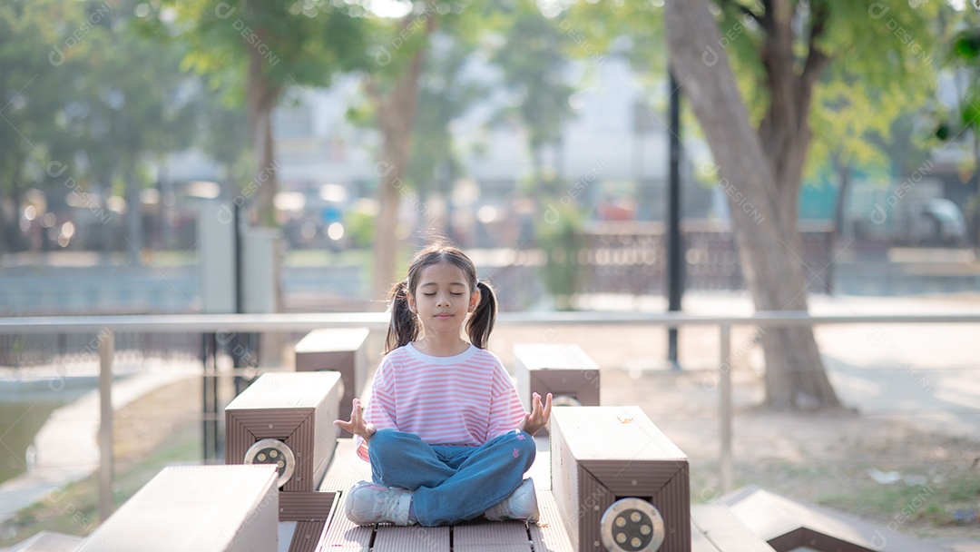 Garotinha fofa meditando em praça