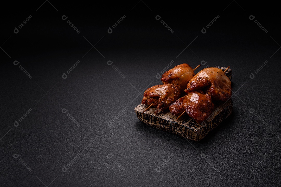 Kebab de frango suculento com sal, especiarias e ervas em um fundo escuro de concreto