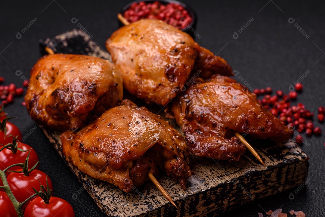 Kebab de frango suculento com sal, especiarias e ervas em um fundo escuro de concreto