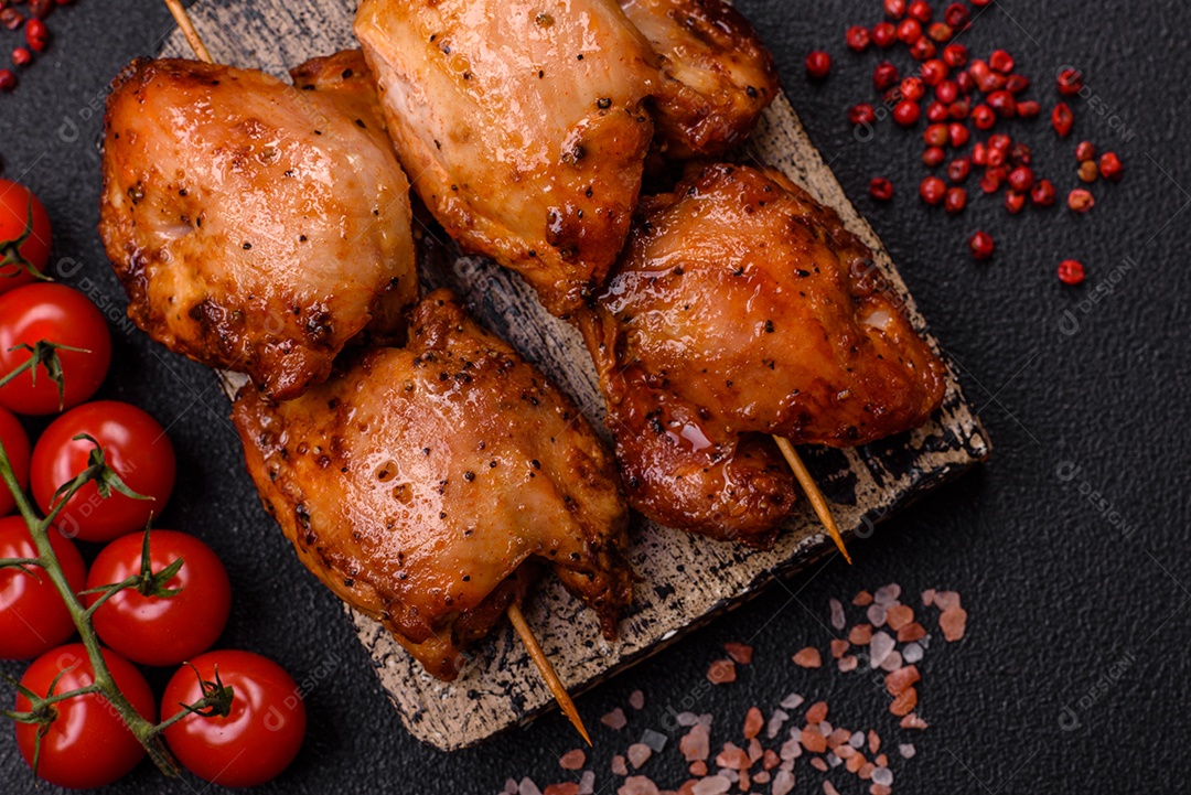 Kebab de frango suculento com sal, especiarias e ervas em um fundo escuro de concreto