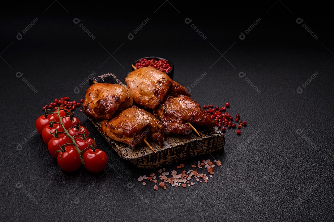 Kebab de frango suculento com sal, especiarias e ervas em um fundo escuro de concreto