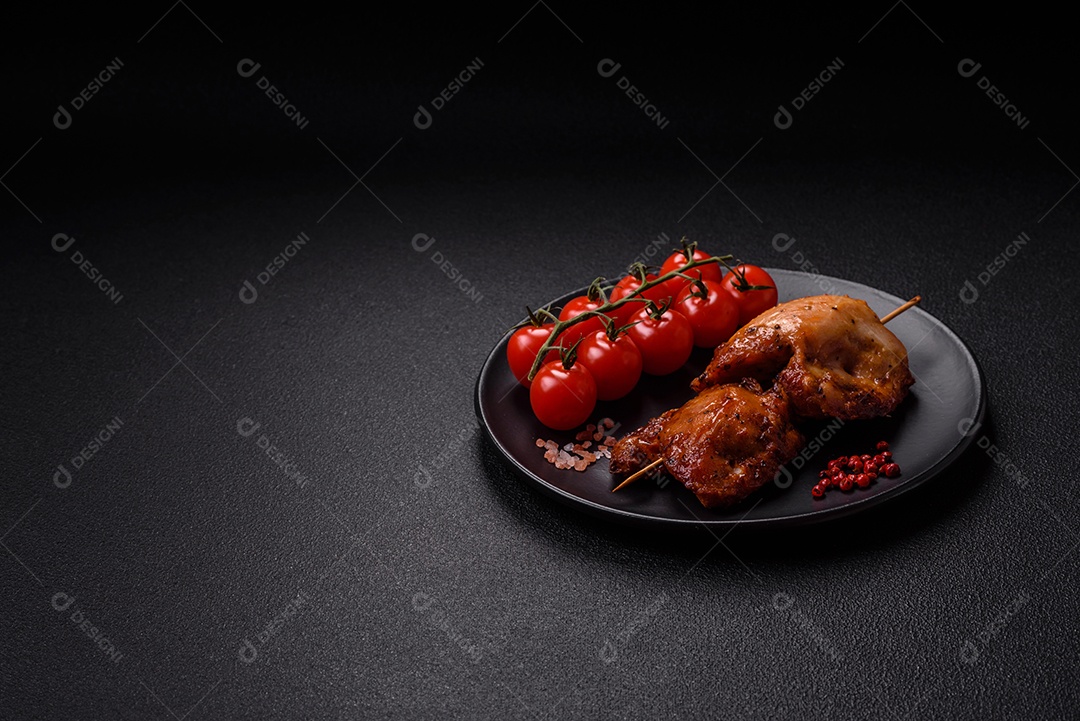 Kebab de frango suculento com sal, especiarias e ervas em um fundo escuro de concreto