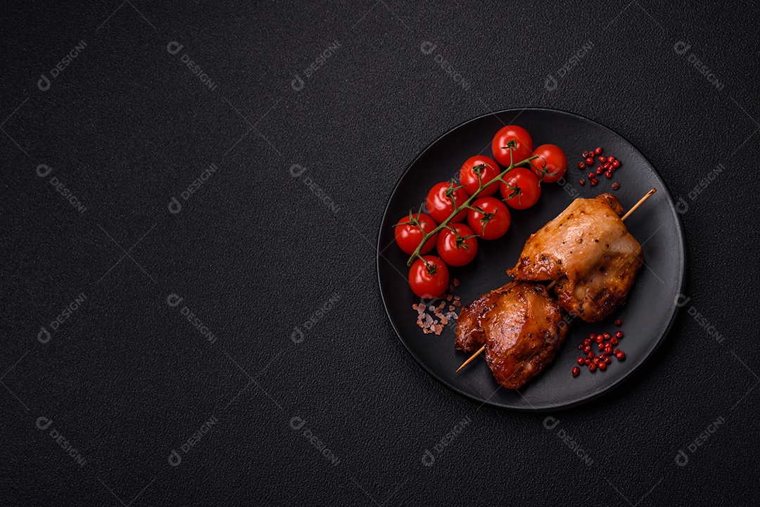 Kebab de frango suculento com sal, especiarias e ervas em um fundo escuro de concreto